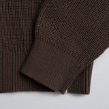 Close-up of a brown knitted garment on a light background.