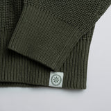 Close-up of a green knitted product with a label on a white background