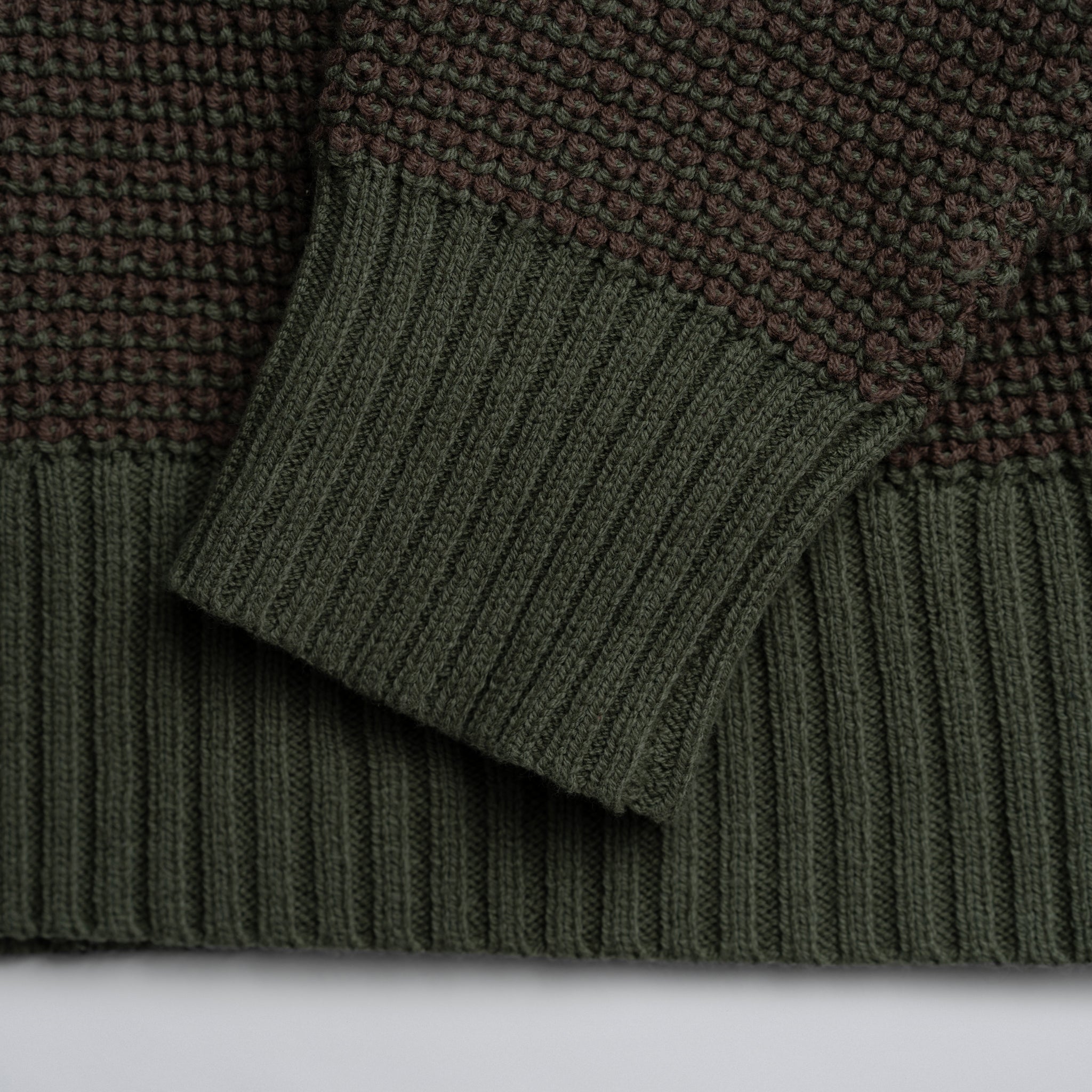 Close-up of green knitted fabric with a plain background