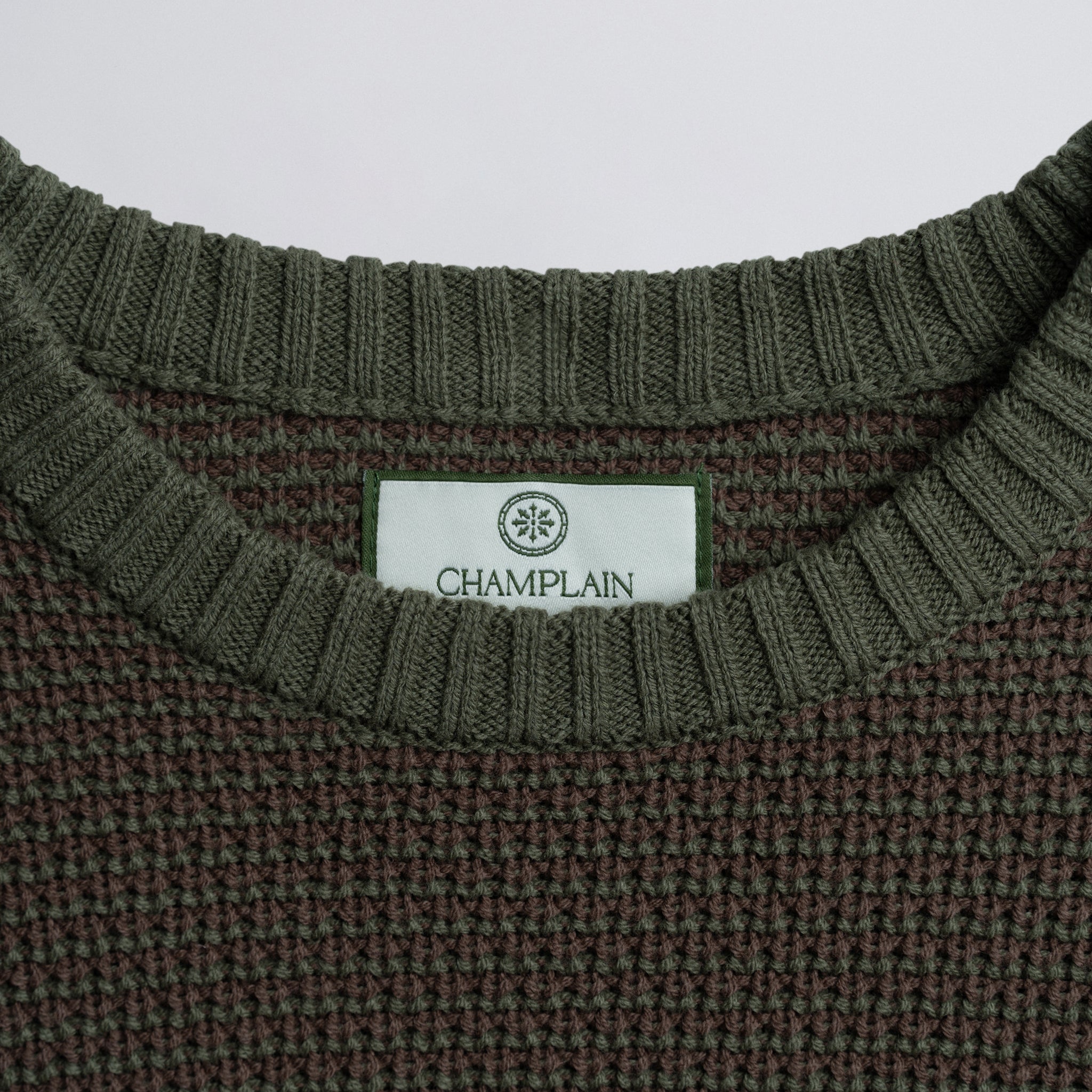 Close-up of a label on a green knitted garment.