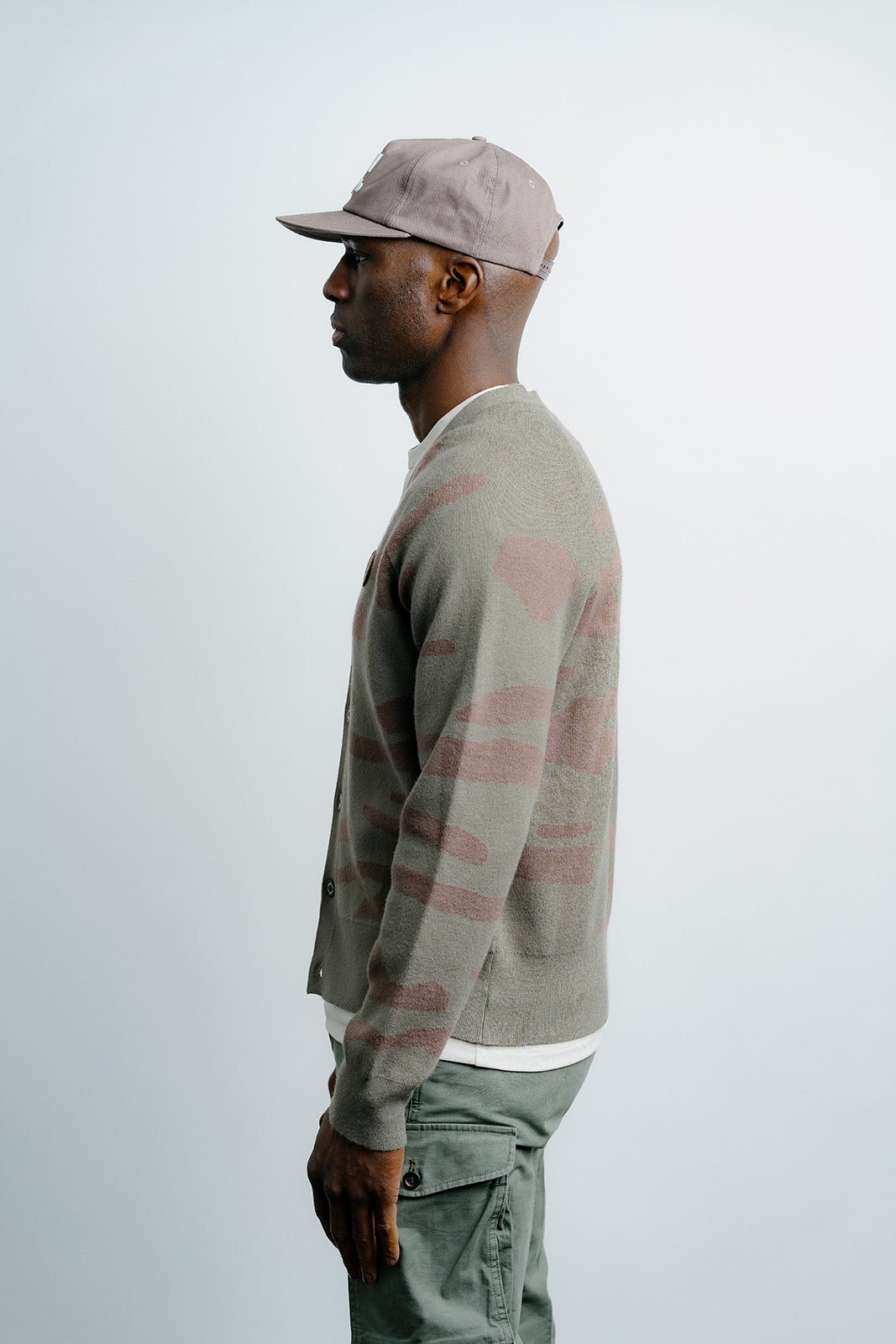 Man wearing a plaid sweater and cap on a white background
