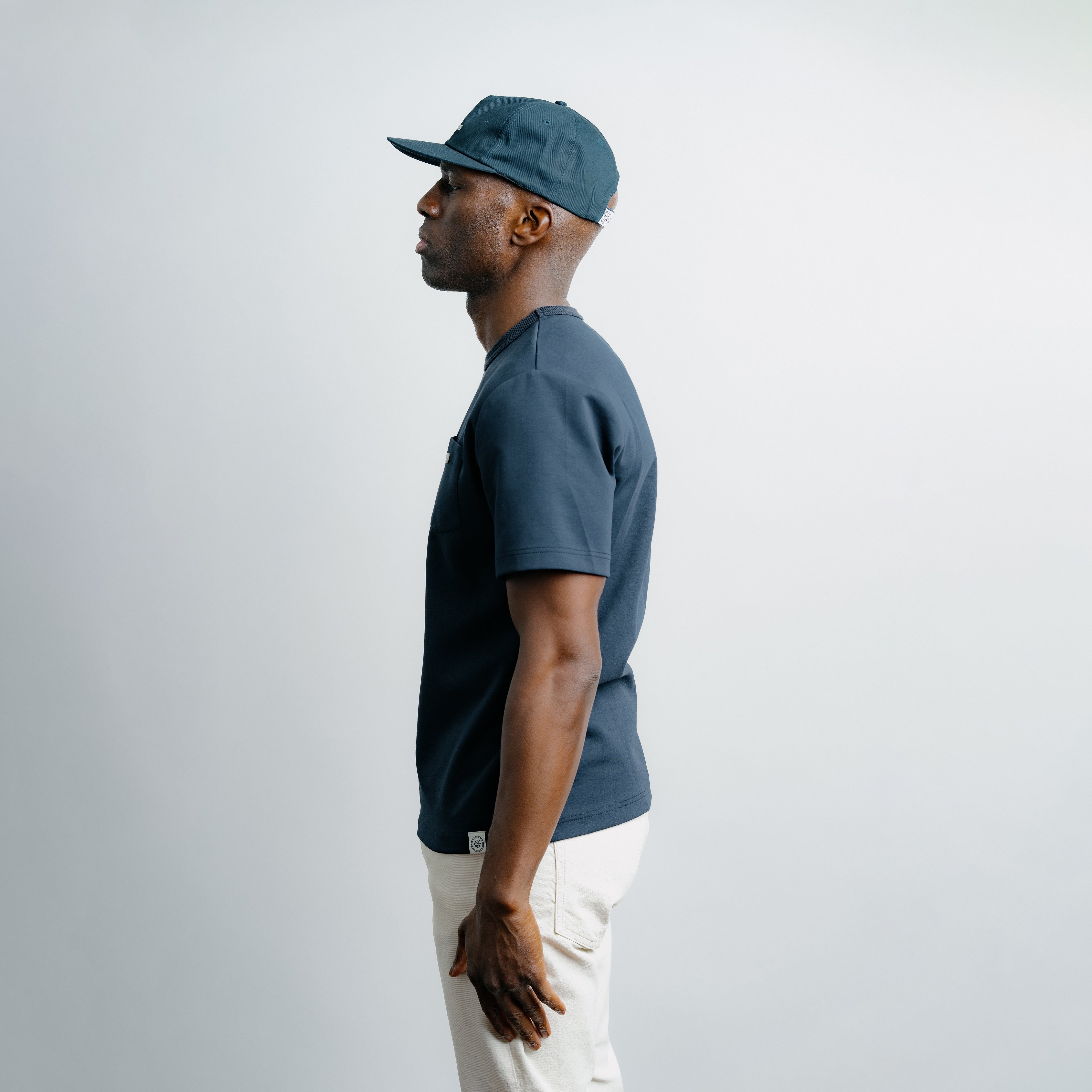 Man wearing a blue cap and shirt against a white background