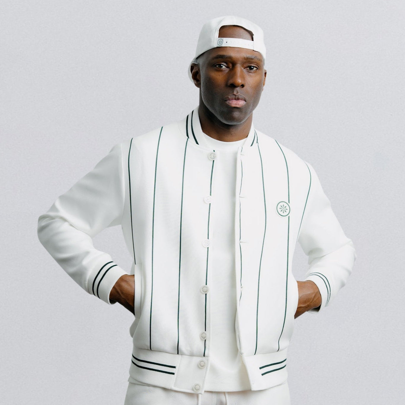 Person wearing a white tracksuit with black stripes on a light gray background