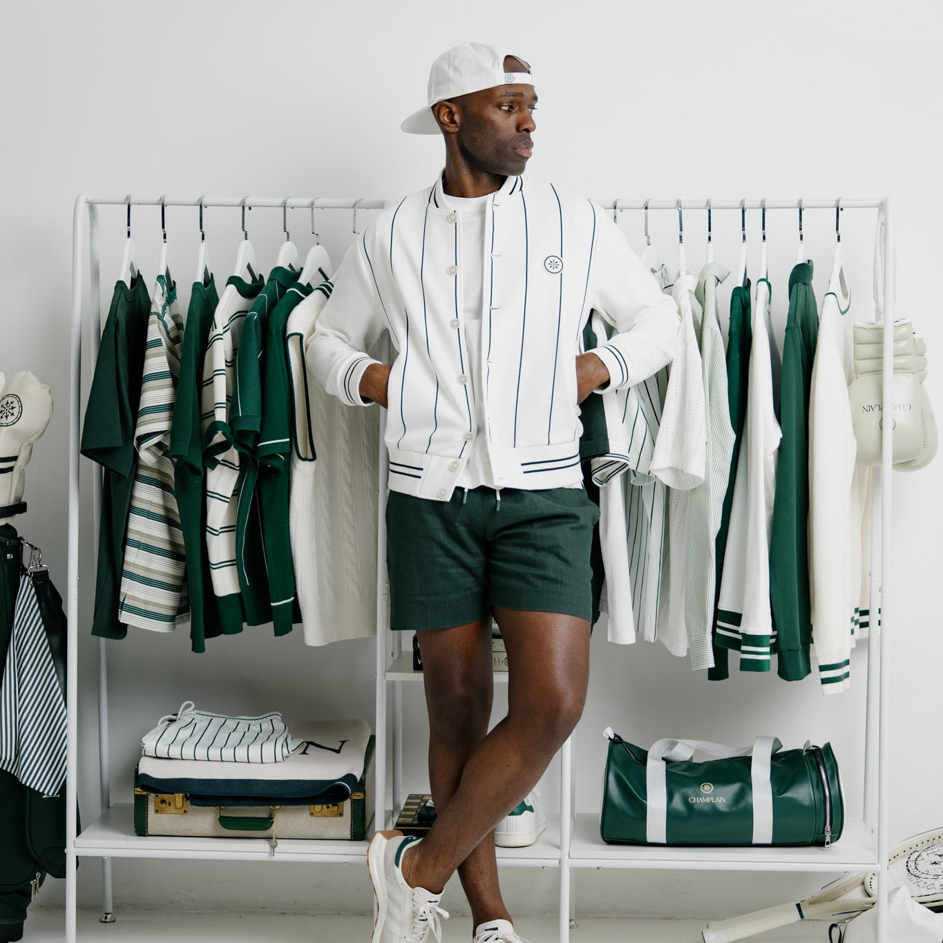 Man standing between two clothing racks with a white and green outfit