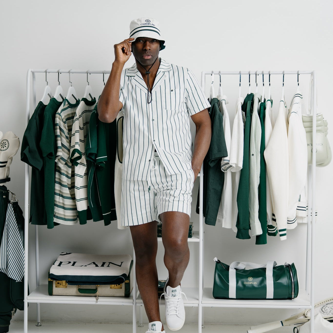 Man in a striped outfit standing in front of a clothing rack with various garments.