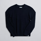 A navy-colored fisherman sweater displayed against a neutral background.