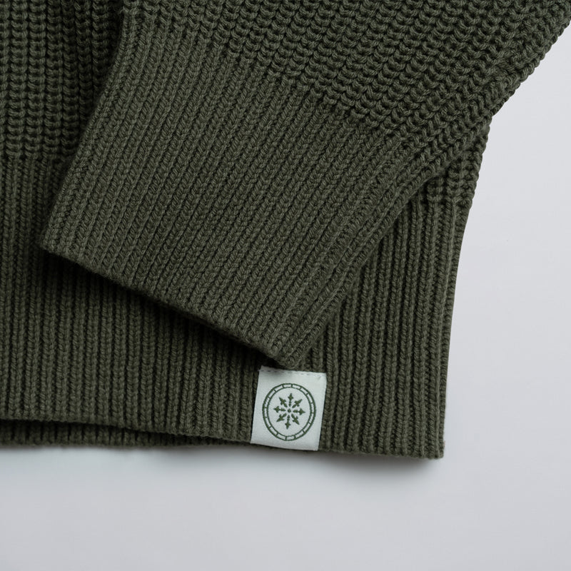 Close-up of a green knitted product with a label on a white background