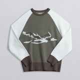 A long-sleeved sweater with a graphic of a duck in white and brown on the front, with a mix of white and green colors across the upper part.