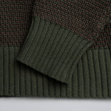 Close-up of green knitted fabric with a plain background