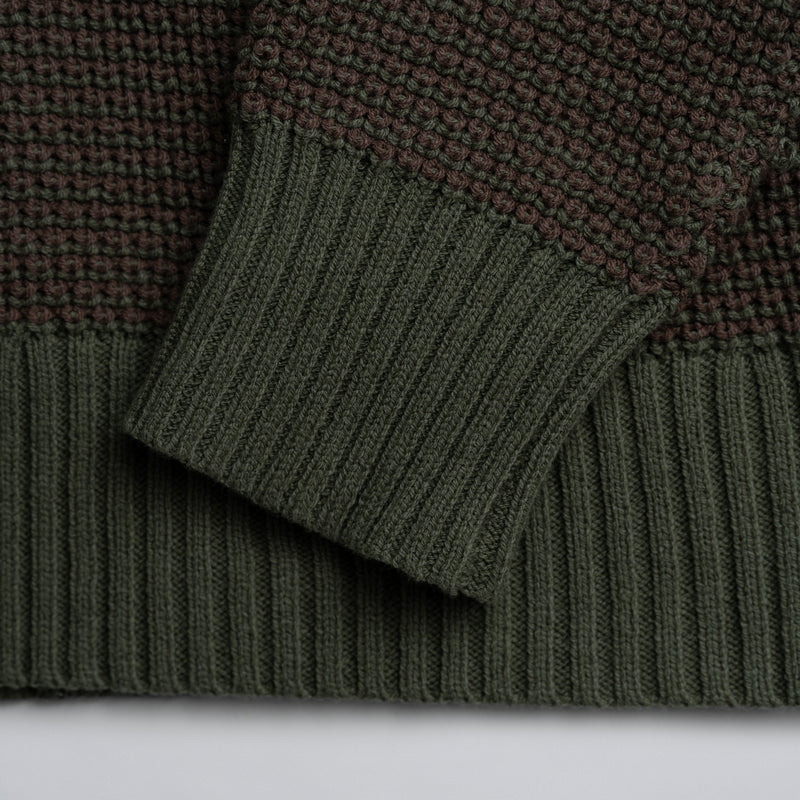 Close-up of green knitted fabric with a plain background