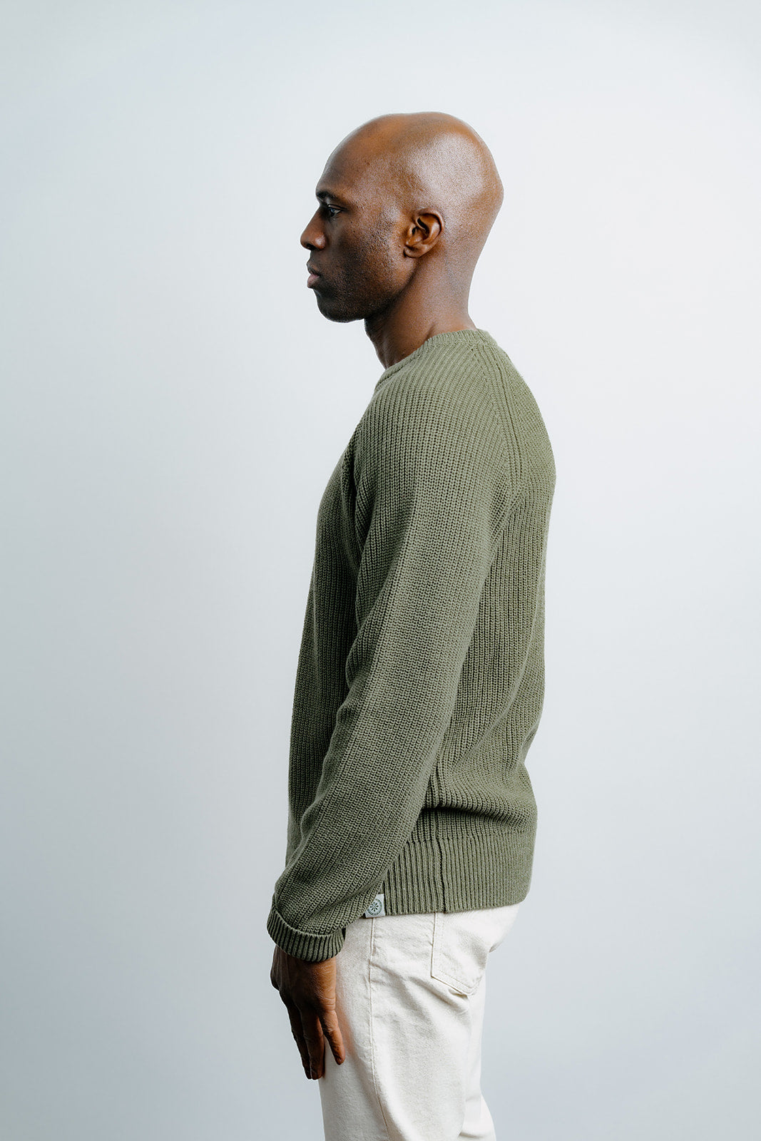 Man wearing a green sweater against a white background