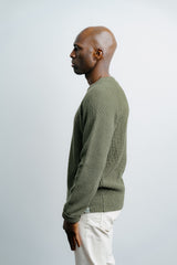 Man wearing a green sweater against a white background